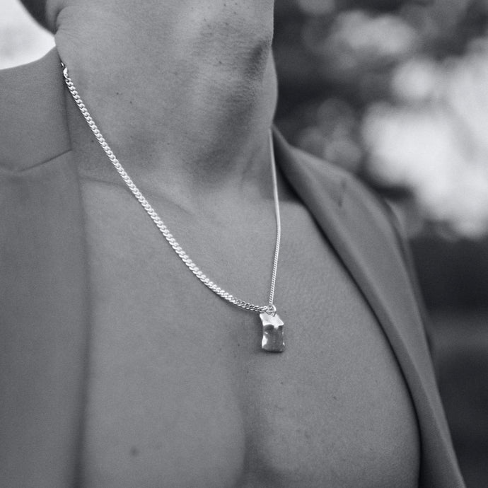 Mood shot of a guy wearing a silver chain 